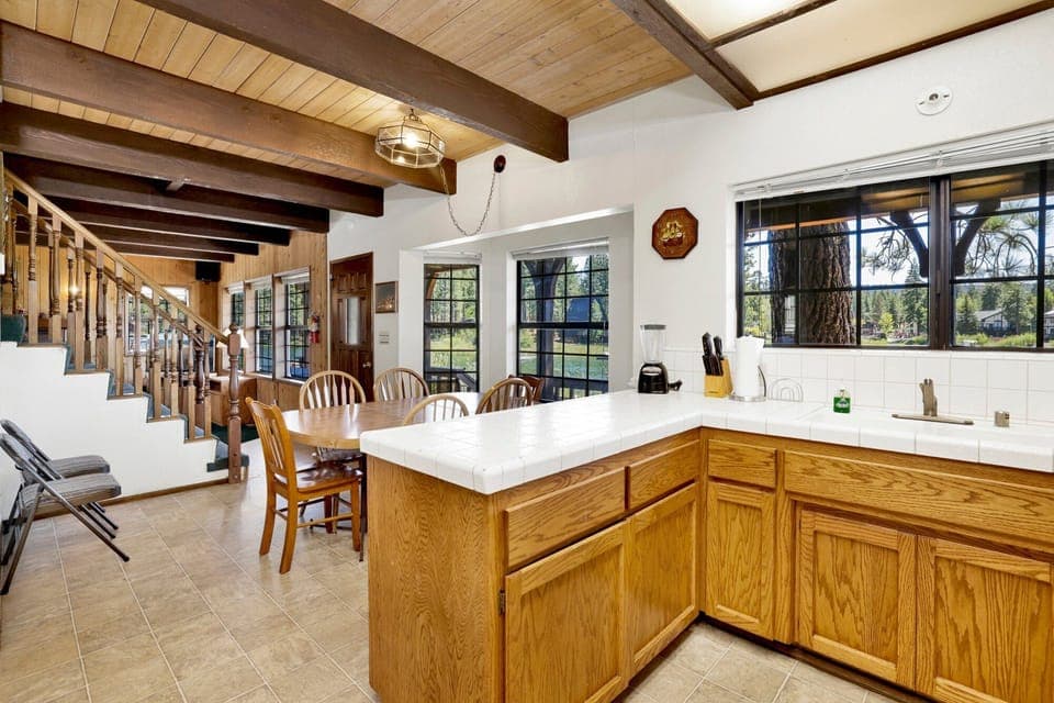 Fully equipped cabin kitchen with warm wood cabinets, stove, fridge, microwave, and coffee maker—perfect for cooking meals, morning coffee, and feeling right at home on your stay.