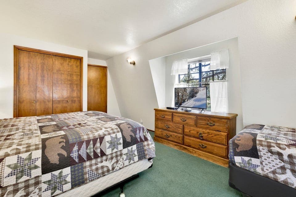 Peaceful cabin bedroom with plush bedding, and beautiful views—ideal for restful nights, cozy mornings, and a relaxing mountain escape.