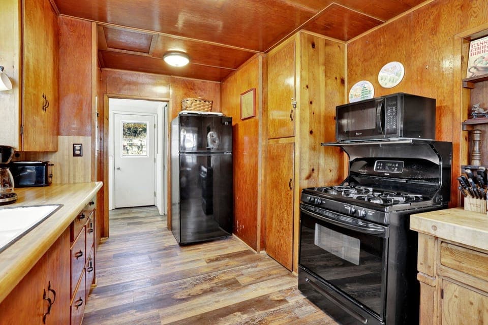 Fully equipped cabin kitchen with ample cabinetry, stove, fridge, microwave, and coffee maker—perfect for cooking meals, morning coffee, and feeling right at home on your stay.