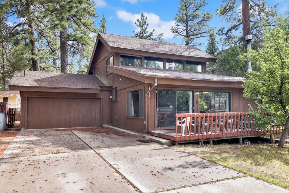 Welcoming cabin entry surrounded by towering pine trees, offering fresh mountain air and a peaceful forest setting—the perfect first impression for your Big Bear Lake getaway.