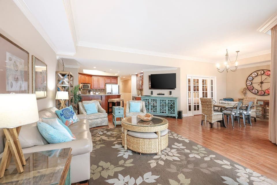 This vibrant living area features a cozy seating arrangement, a large TV, and a stylish dining table, perfect for gatherings