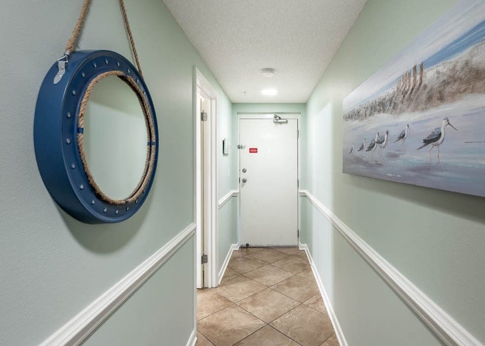 Step into a welcoming hallway adorned with coastal decor, leading you to the heart of your vacation retreat