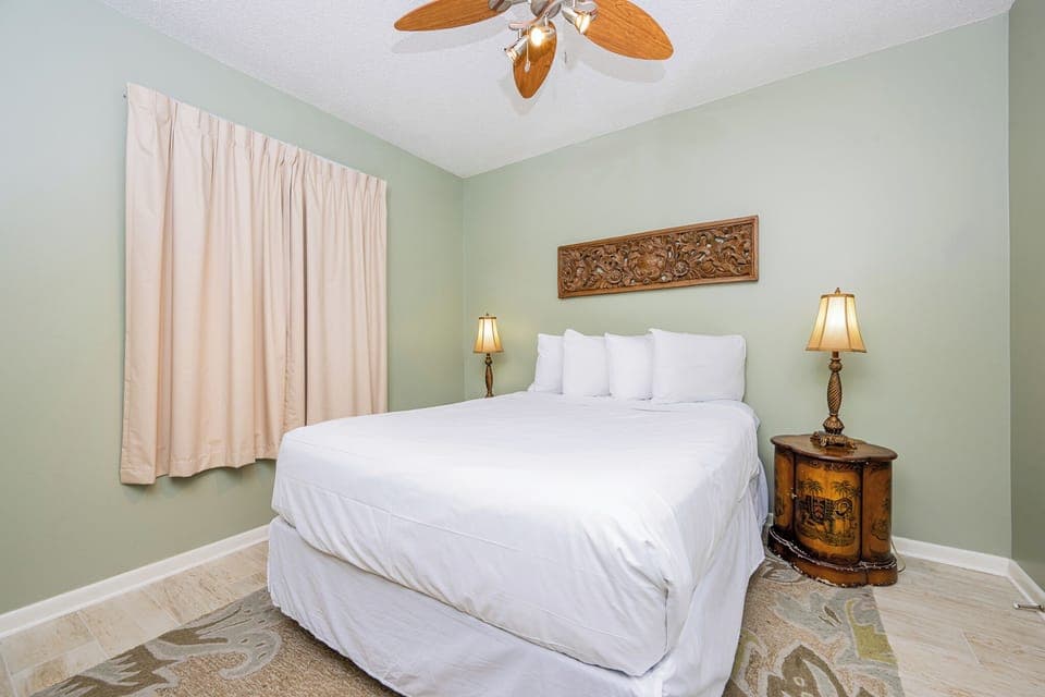 Rest comfortably in this inviting guest room featuring a queen bed, decorative accents, and soft lighting for a restful stay