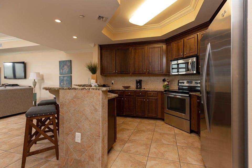 This kitchen features stainless appliances, granite countertops, and a bar area, perfect for casual dining and entertaining