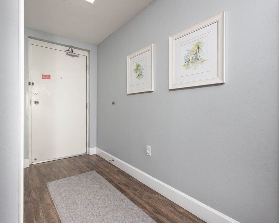 Step into a welcoming entryway adorned with charming artwork and a cozy rug, setting the tone for your stay