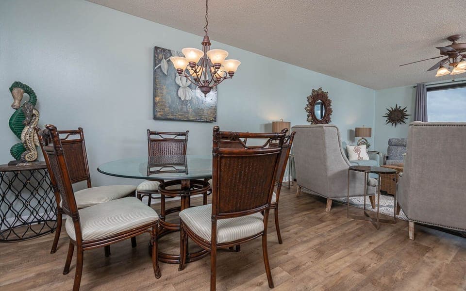 Gather around the glass-top dining table, surrounded by stylish chairs and coastal decor for a relaxing meal
