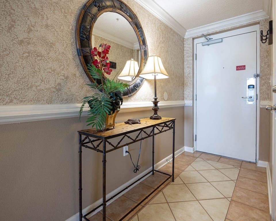 Enter a welcoming hallway featuring a decorative mirror, a stylish table, and soft lighting for a warm first impression