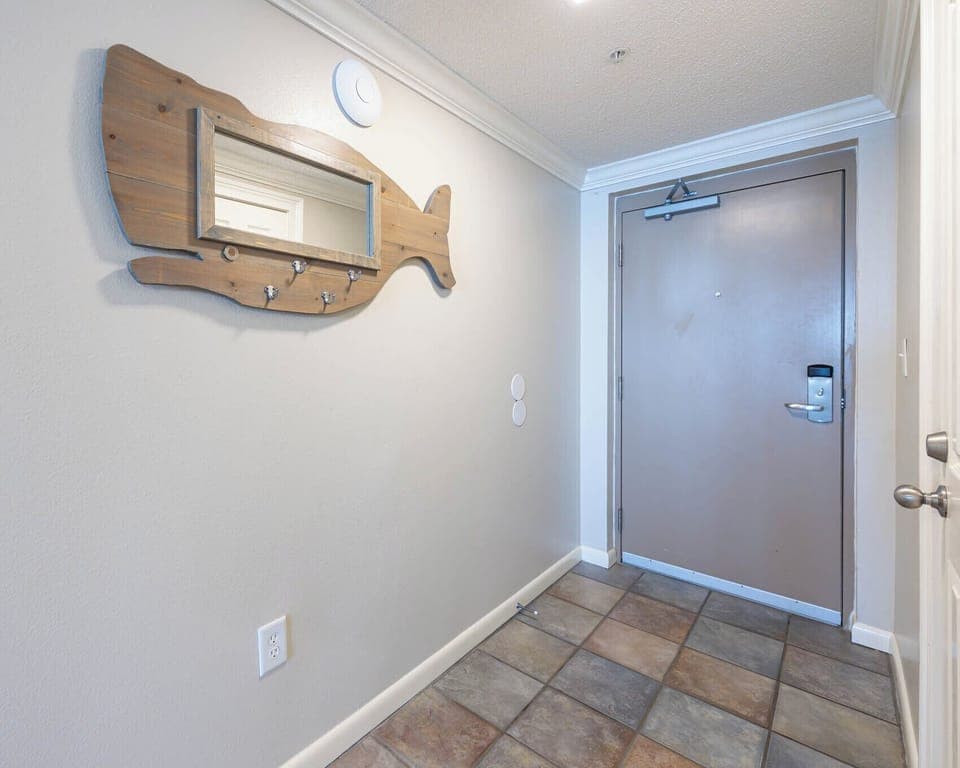 Step into a welcoming entryway featuring a charming fish-shaped mirror and convenient hooks for your belongings