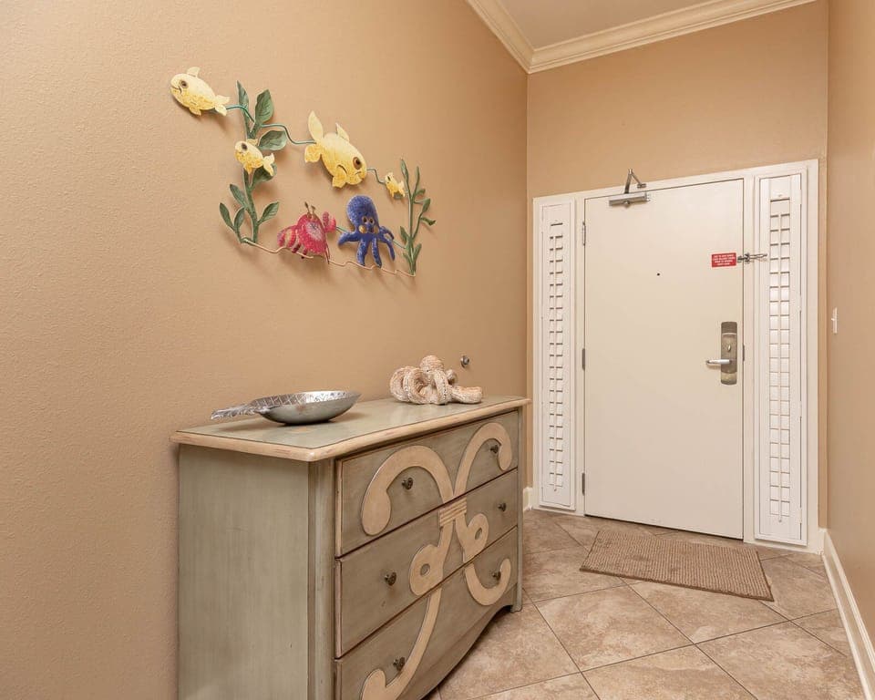 This welcoming entryway features playful fish decor and a stylish dresser, setting a cheerful tone for your stay