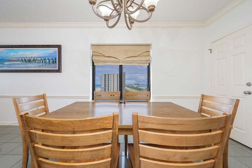 Gather around the wooden dining table while enjoying views of the coast through the large window
