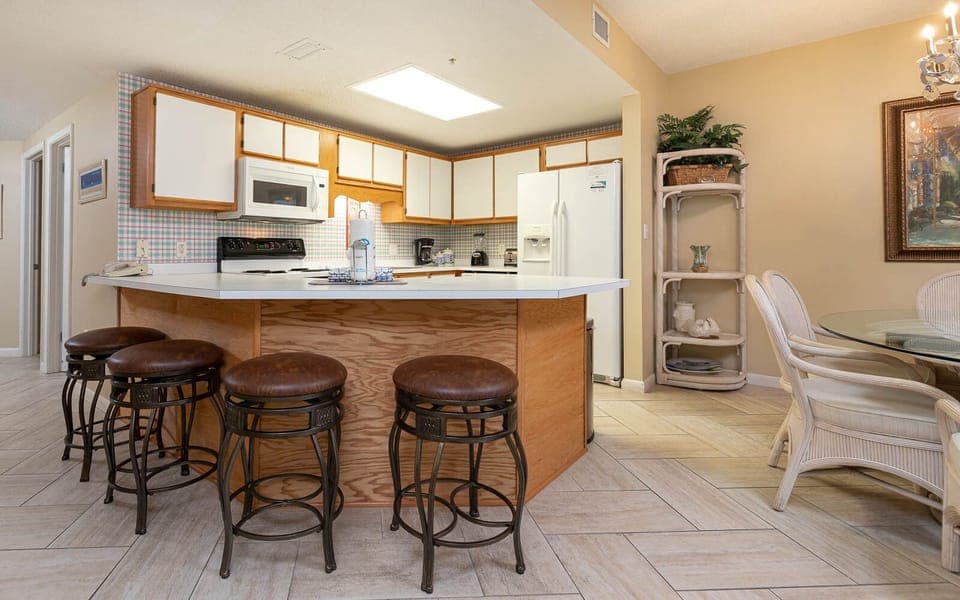 Enjoy meals at the breakfast bar with stylish seating, surrounded by a bright kitchen and inviting decor