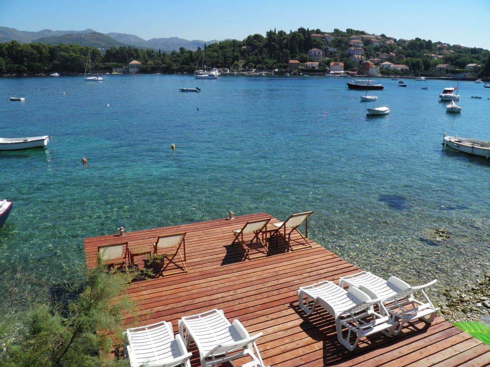 Private wooden pier with the beach in front of the house
