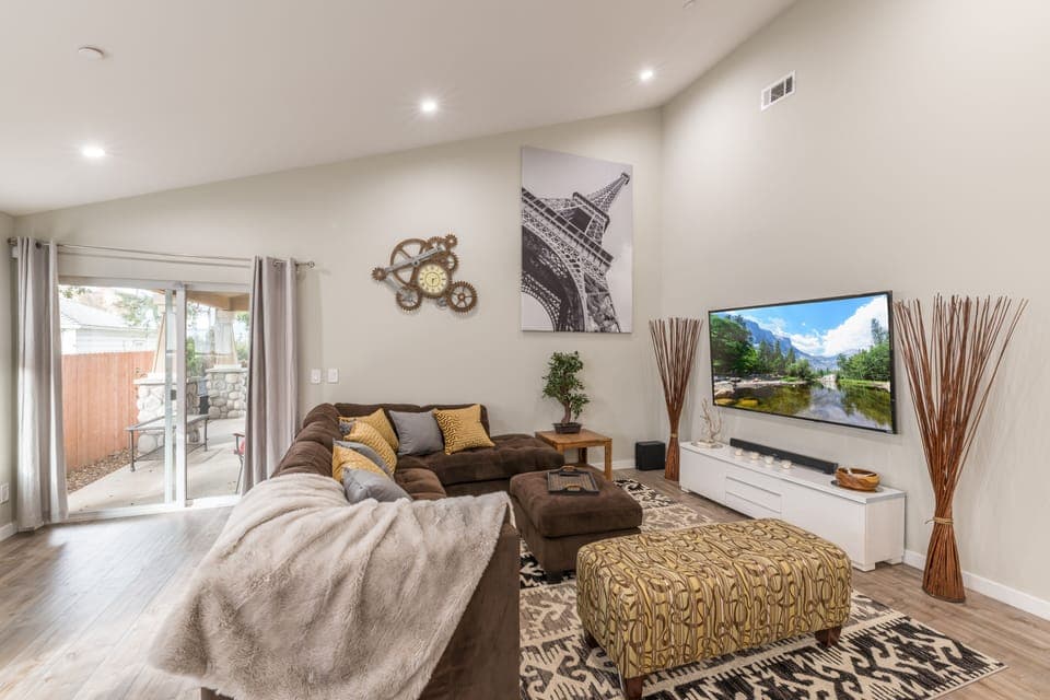 Open concept living room with 20' ceilings and 75" 4K HDTV and cabe TV. 