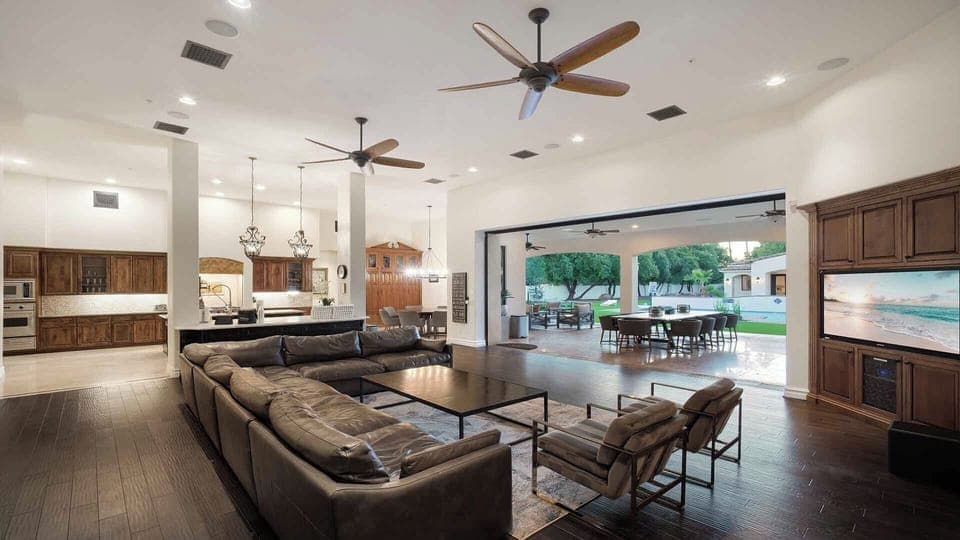 Spacious open-concept living room with chef’s kitchen and patio views