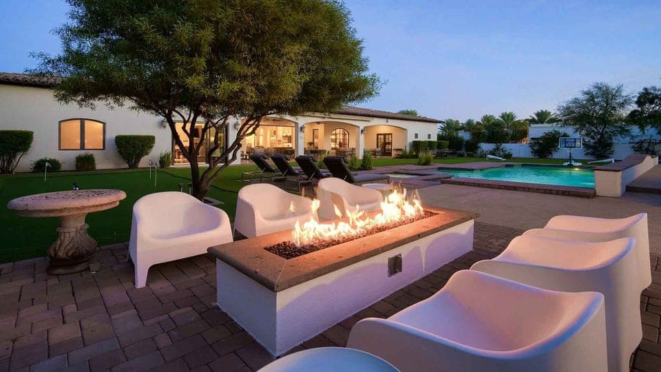 Seating around the fire feature, next to the pool and spa