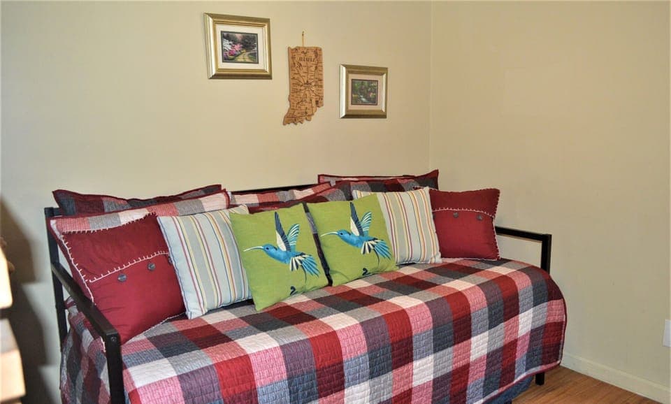 Daybed in dorm room with TV area.