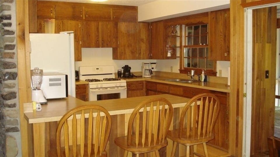 Wormy chestnut custom cabinets and maple floors warm the well-appointed kitchen