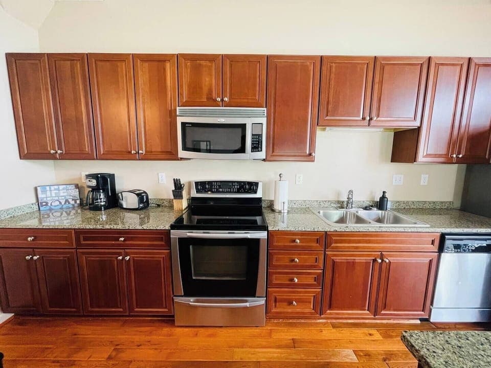 Fully Equipped Kitchen
Cook with ease in this spacious kitchen featuring rich wood cabinetry, stainless steel appliances, and granite countertops. Perfect for preparing home-cooked meals or quick snacks!