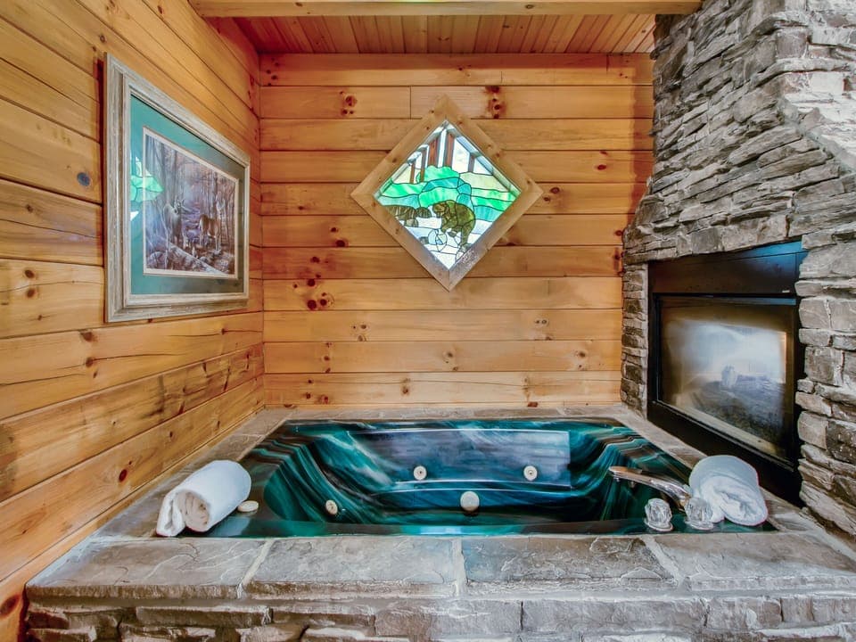 Find solace and peace relaxing in the Jacuzzi tub. Enjoy the warm glow of the fireplace and while also admiring the beautiful stained-glass window.
