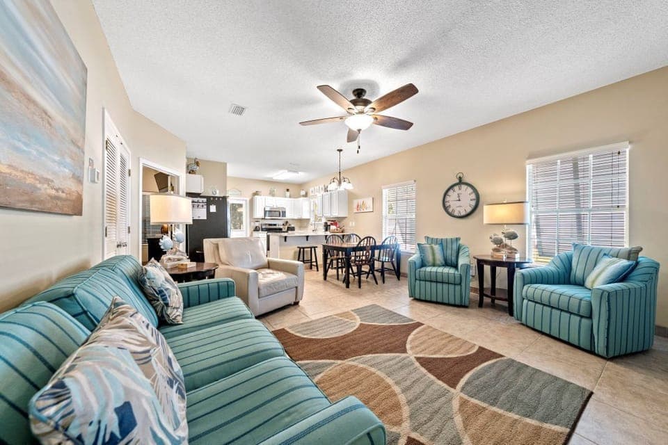 Sink into plush turquoise seating in this open-concept haven where coastal charm meets modern comfort for your perfect getaway.