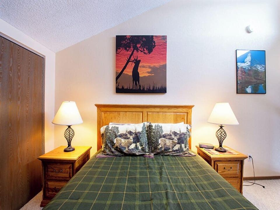 Sink into cozy comfort in your rustic bedroom with warm wooden furnishings and peaceful nature-inspired artwork setting the perfect mood for rest.