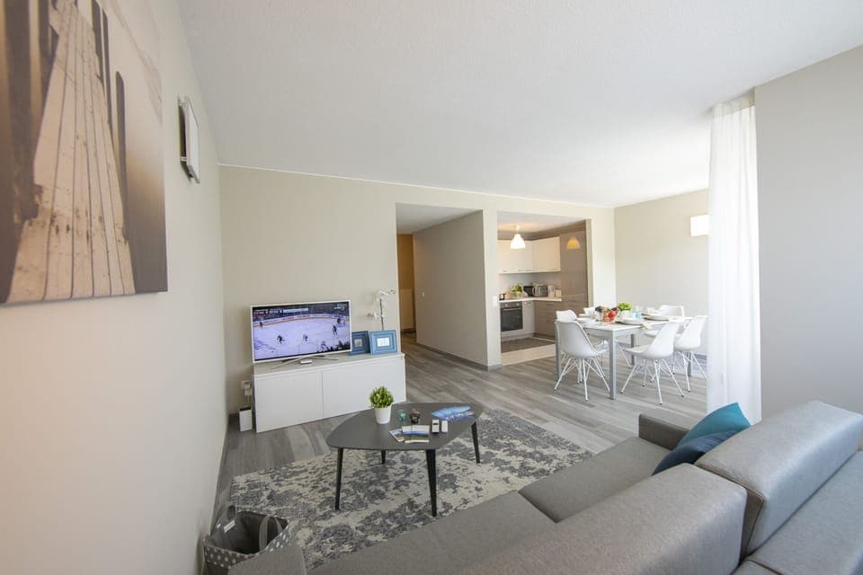 Living room with a sitting area, television and dining area