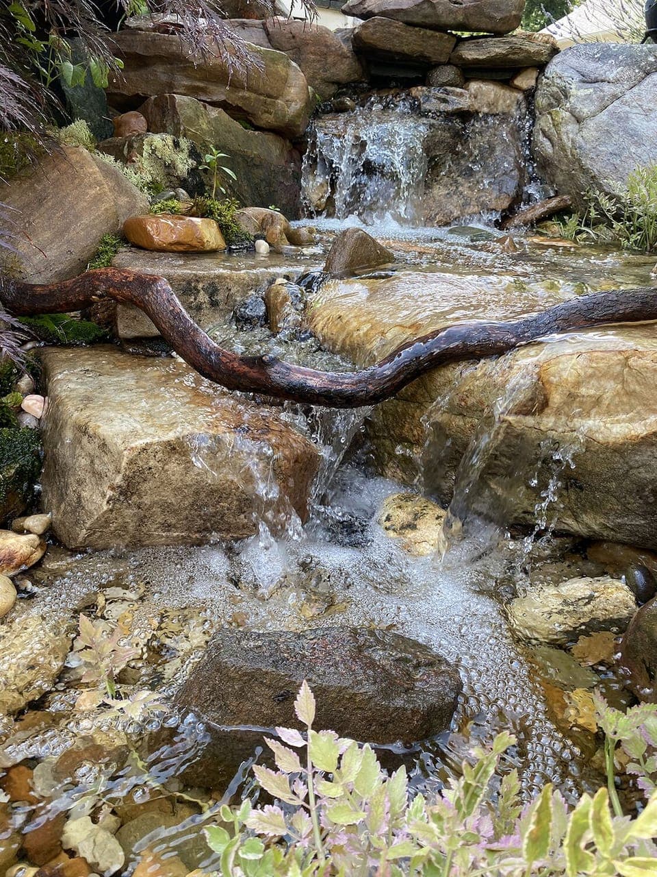 Beautiful gardens include a waterfall & creek along the side of the property.