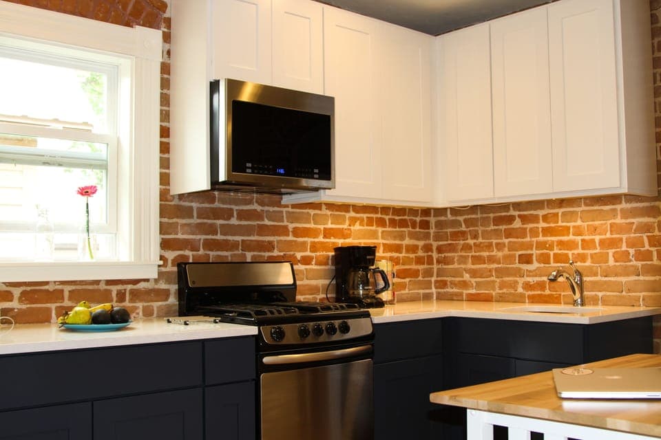 A cozy updated kitchen with historic exposed brick. 
