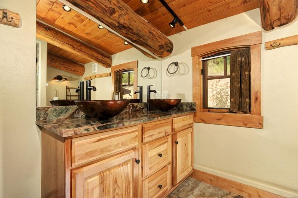 Grand master bathroom with double-sink vanity and glass shower.