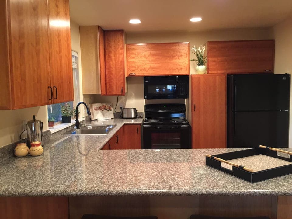 fully equipped kitchen with peninsula counter and stools