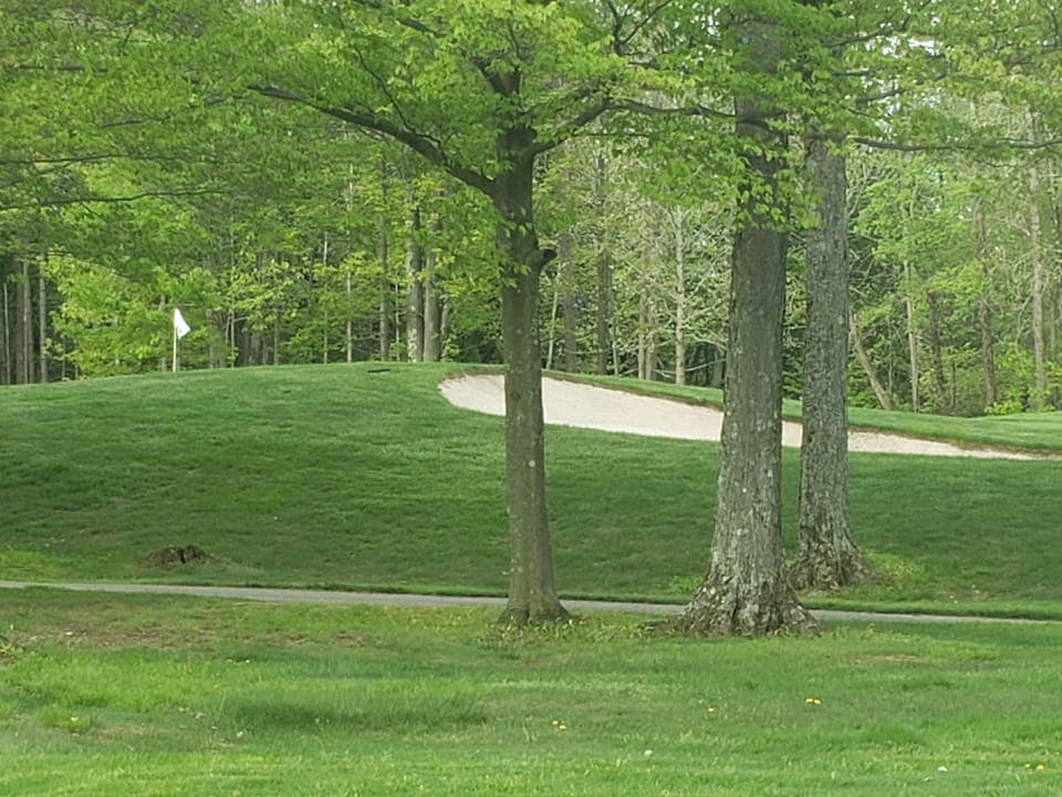 Close to the bag drop for the Upper Course and across the street from Hole 9.