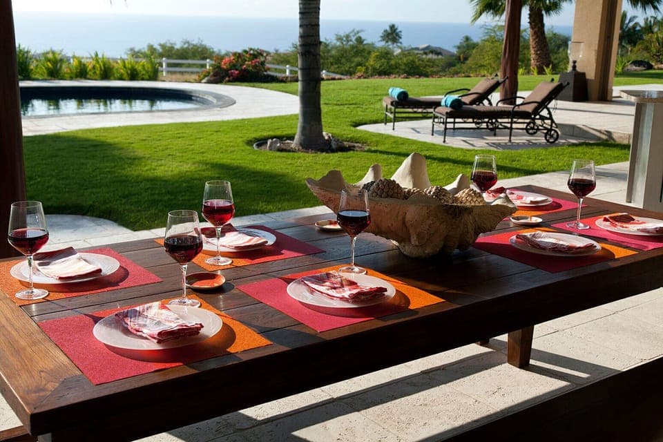 Outdoor dining under covered lanai with ocean and pool views.  Ideal climate 