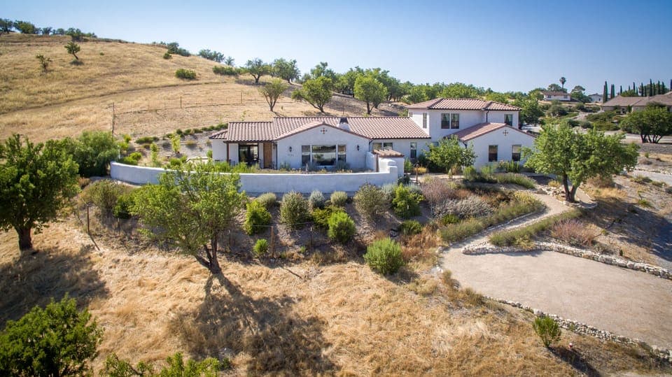 A beautiful Spanish style modern home surrounded by drought tolerant landscaping