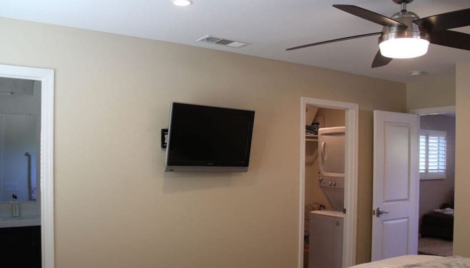 Flat-screen TV in the bedroom of the short term rental property.