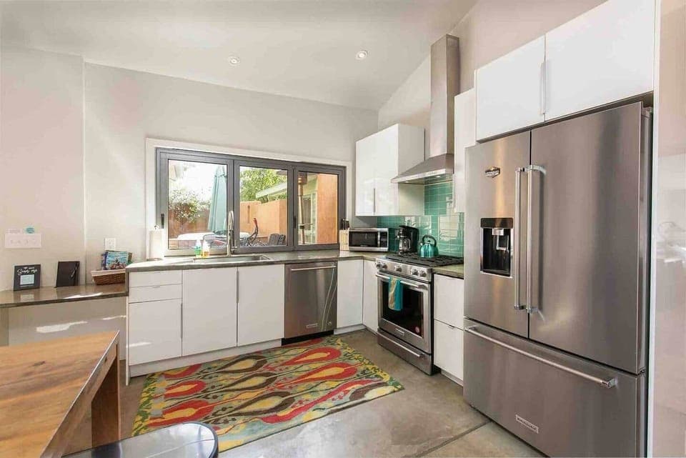 Bright modern kitchen with accordion window that opens to courtyard.