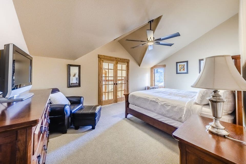 2nd Bedroom - King bed, dresser, and French doors that open to a pseudo-balcony overlooking the main living area below.

This property uses the Triple Sheet Method where we use two sheets to encase the comforter.  This sheet-made duvet cover gets washed between each and every guest to provide an extra clean sleeping experience.