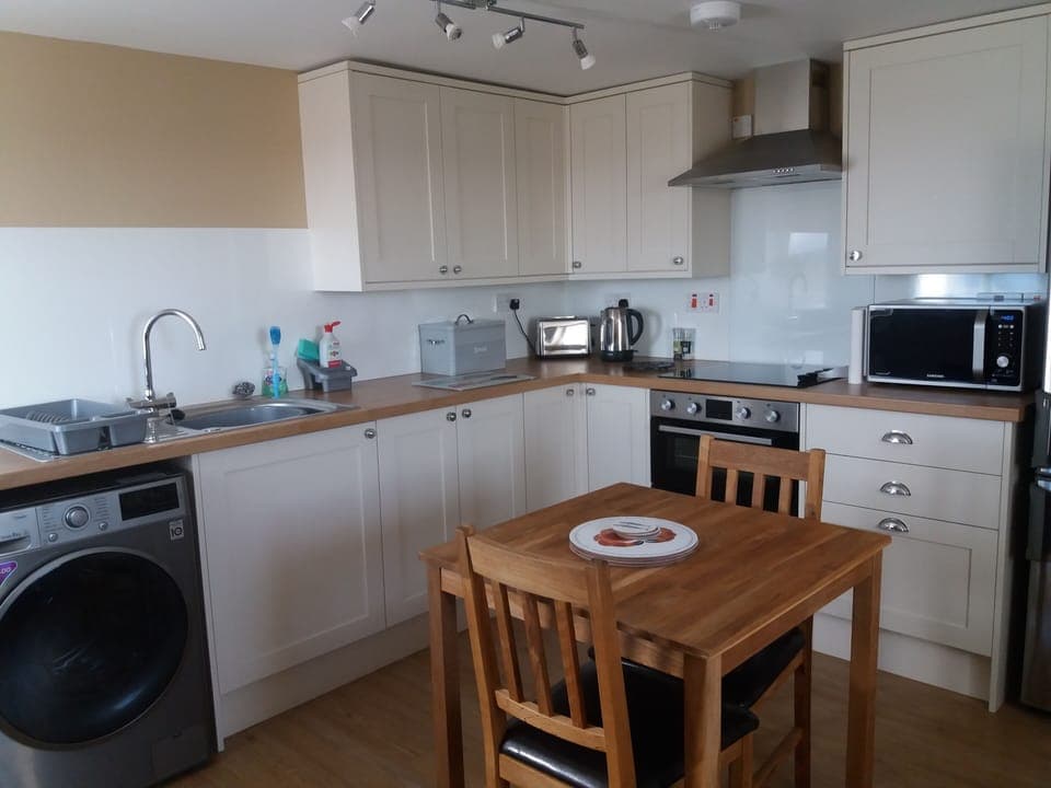 Kitchen area fully equipped with larder fridge freezer, cooker, and microwave.