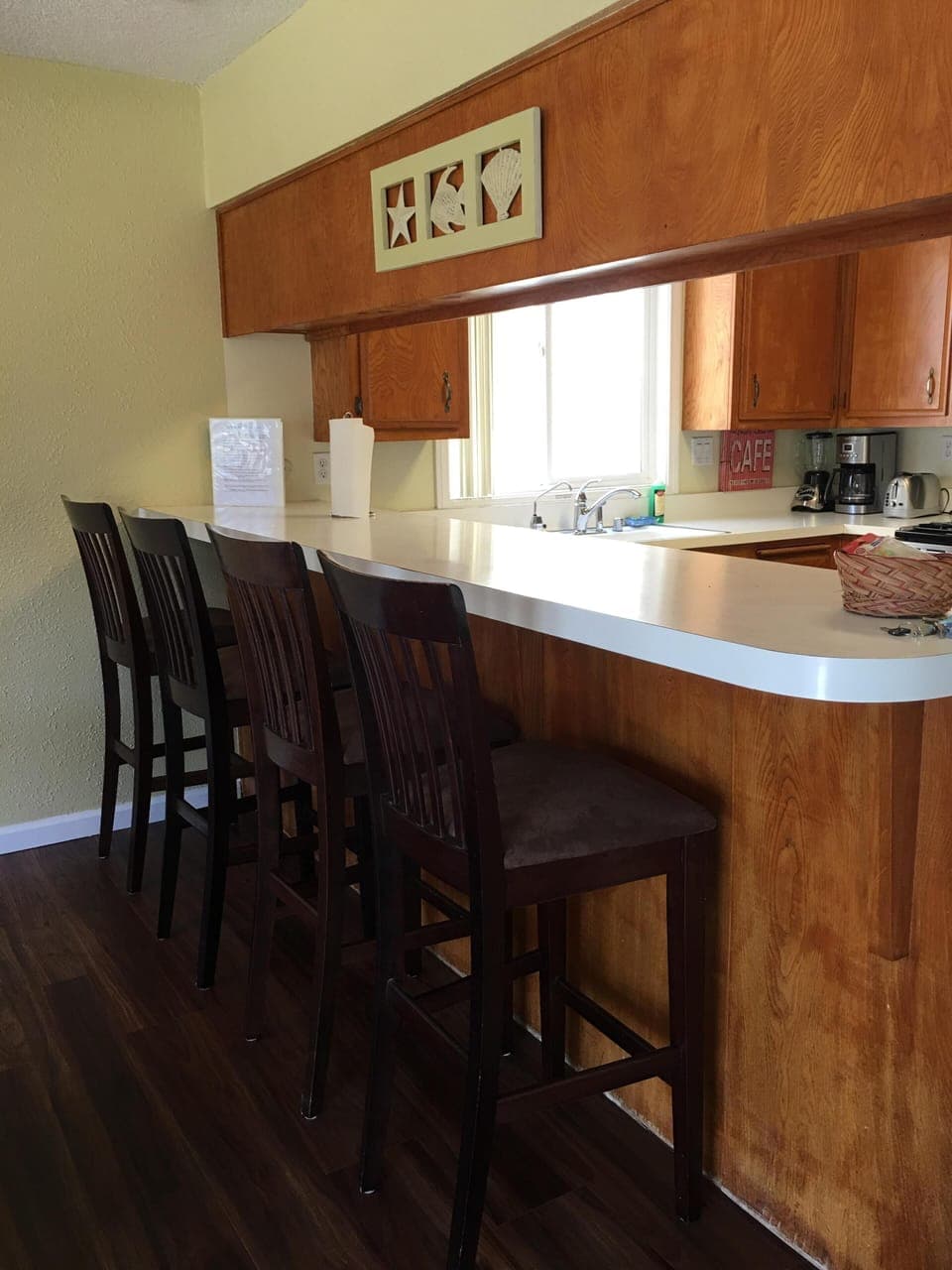 Kitchen counter with four bar stools.