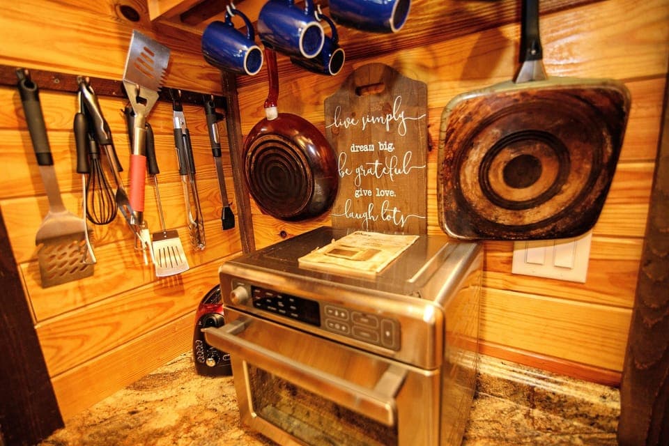 - Cabin cooking nook with tools and oven setup   - Rustic kitchen essentials for forest getaway meals   - Cozy prep space designed for easy cabin cooking