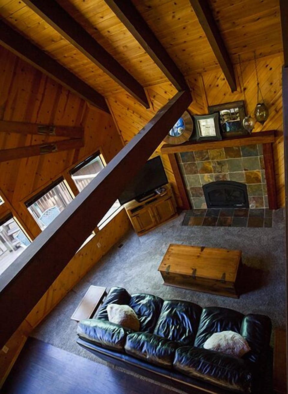 View of warm and cozy living area with high vaulted ceiling and gas fireplace.