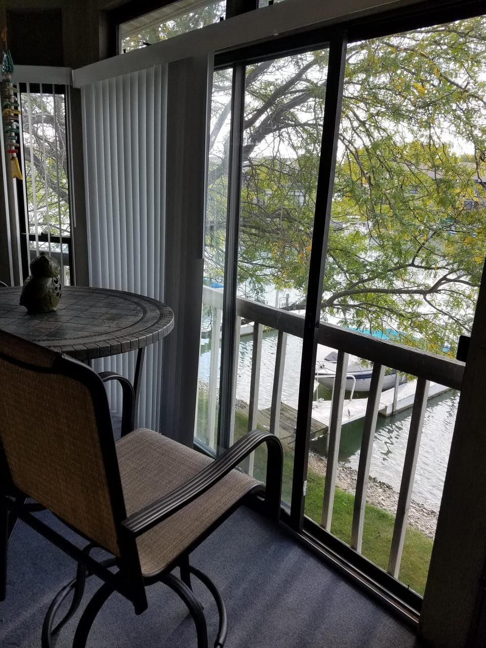 Balcony with table and two chairs. Stair access to dock