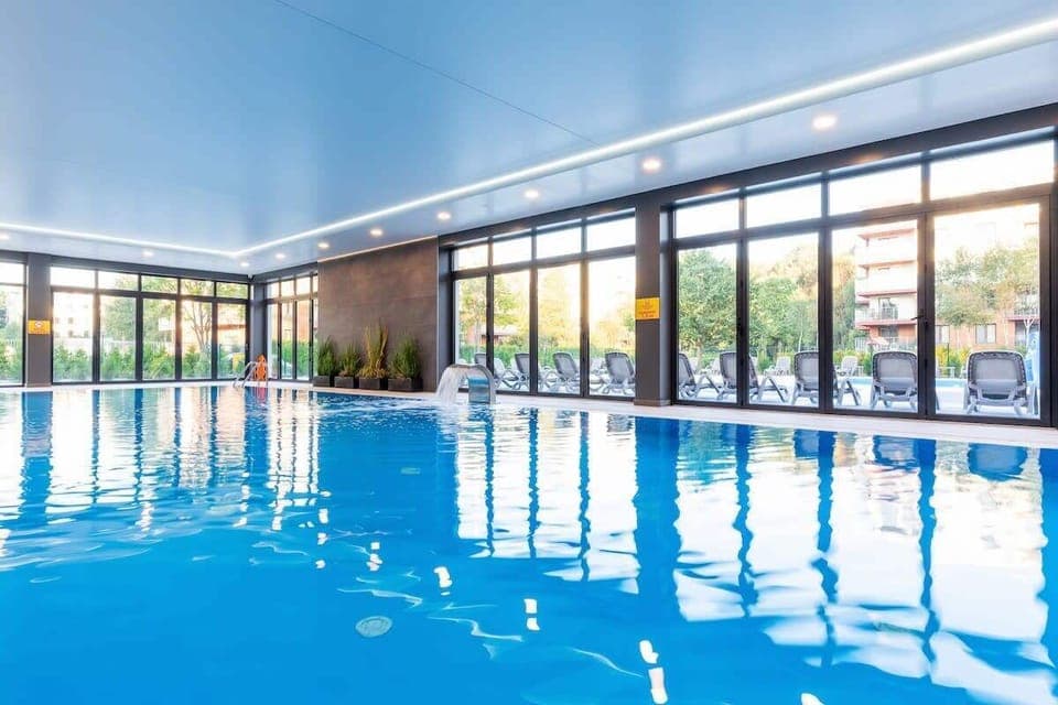 A large bright space where there is an indoor swimming pool.