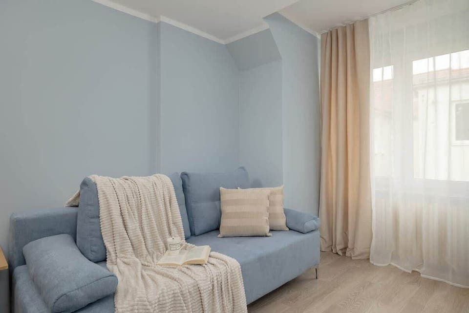 A cozy seating area with a grey sofa and neutral pillows. Soft lighting adds a warm and inviting touch.