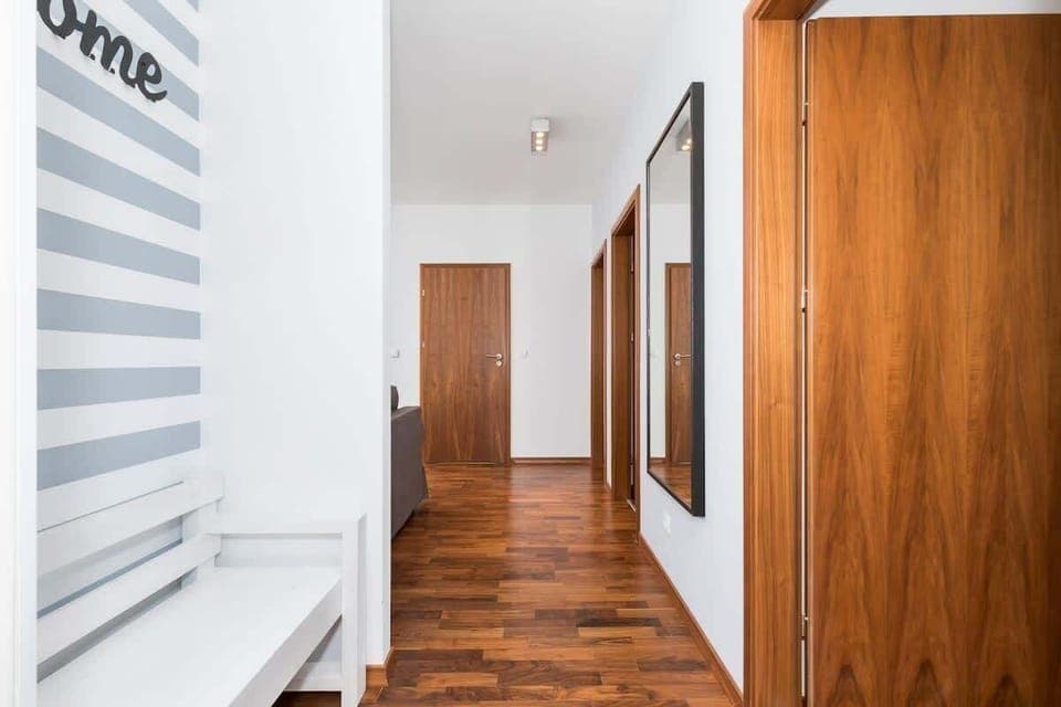 Hallway with white walls and a white wardrobe from which the entrance to the rooms leads. 