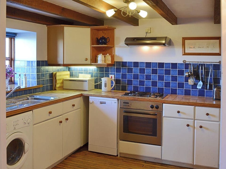The contemporary half tiled kitchen is fited with up to date appliances to make mealtimes a pleasure, not a chore | Coachmans Cottage, White Cross, near Newquay