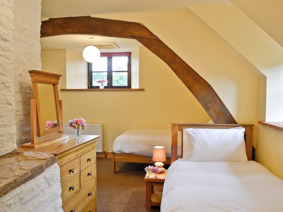 Twin bedroom with exposed wooden beams | Mill Cottage, Peterchurch, near Hay-on-Wye