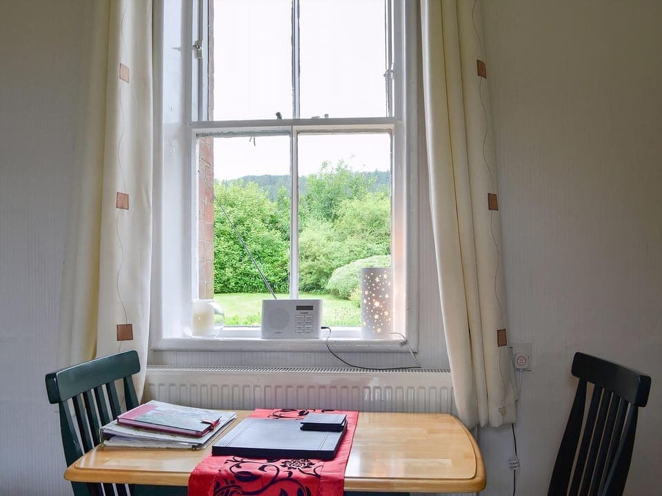 Compact dining area with wonderful view over the garden to the fells beyond | Ticket Office - Torver Station Cottages, Torver, near Coniston