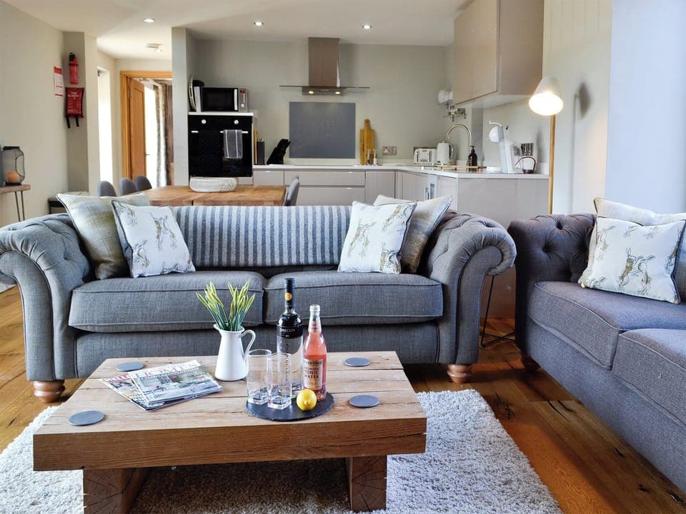 Open plan living space with beams and oak floors | Maes Merlin, Llanddeusant, near Llangadog