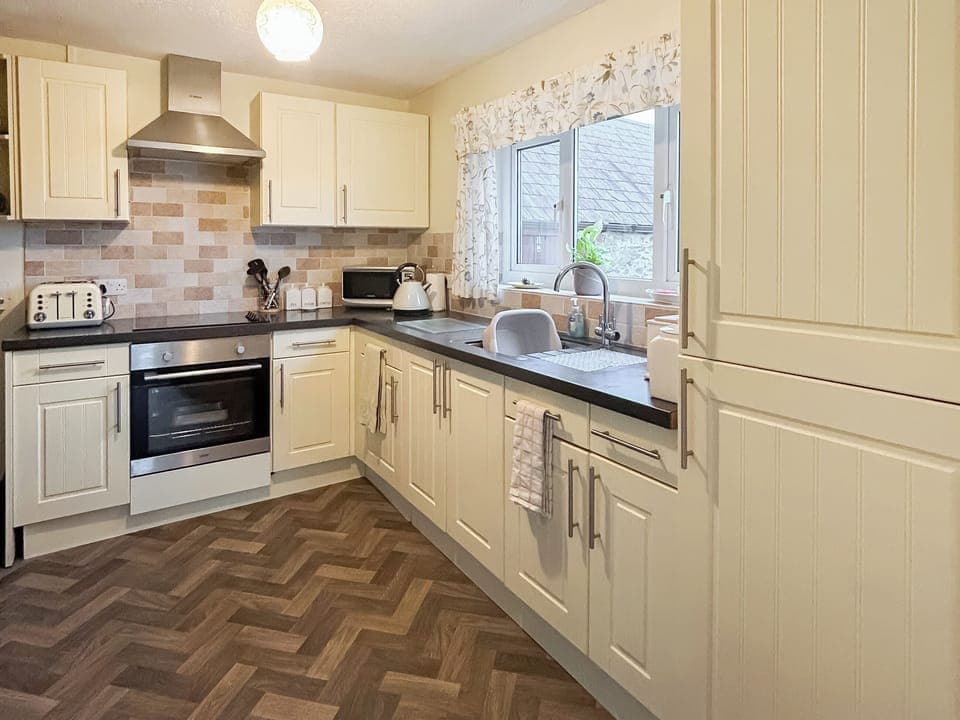Fully equipped kitchen with electric oven, electric hob, microwave, fridge/freezer and washing machine | Ty Main Cottage, Newborough, near Llangefni