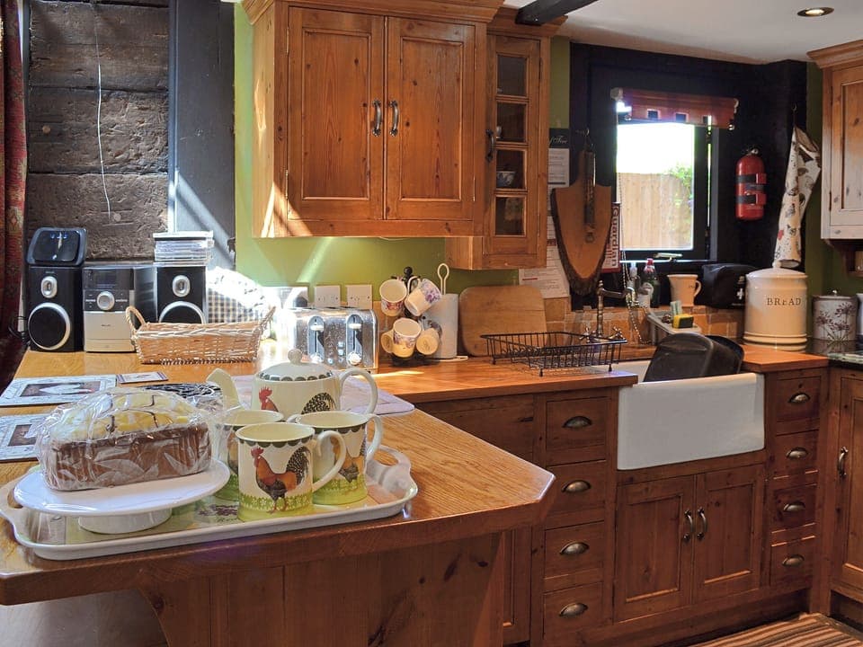 The property features a traditional handmade kitchen with wood topped breakfast bar | Brook Barn - Brook and Meadow Barns, Shobley, Ringwood